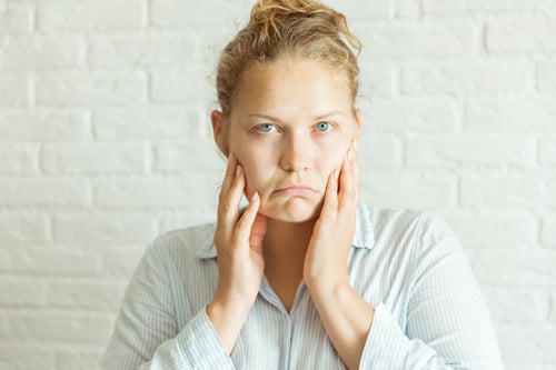 Woman touching her face concerned about skin aging and looking for ways to slow aging naturally