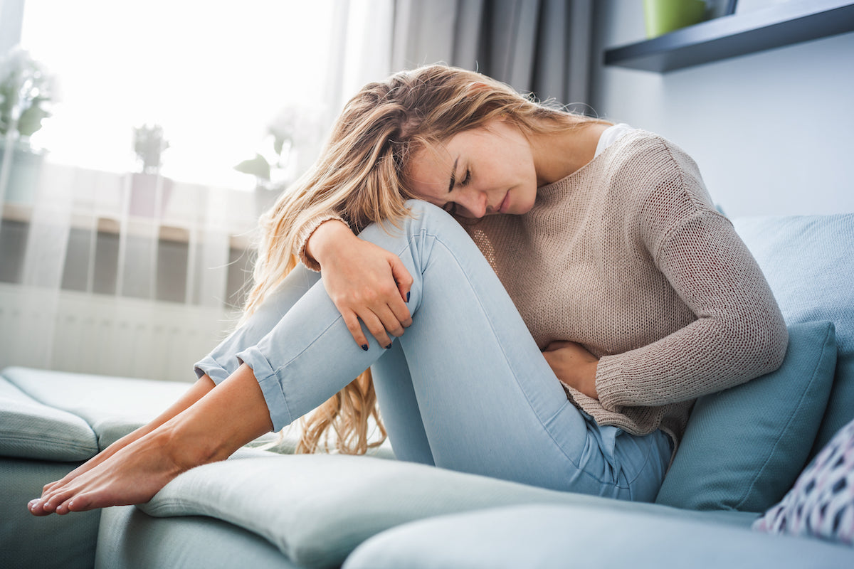 woman hunched over in pain from IBS